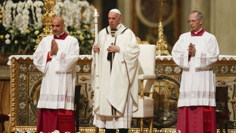 Pope Francis holds a candle as he presides over a solemn Easter vigil ceremony in St. Peter's Basilica at the Vatican, Saturday, April 21, 2019. (AP Photo/Gregorio Borgia)
