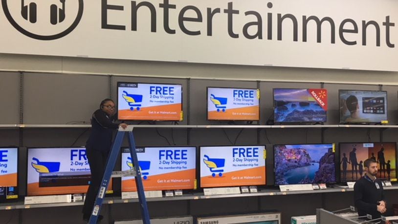 Dadrea Duffey connects televisions in the redesigned electronics department at Walmart Supercenter in Fairfield Twp. CONTRIBUTED