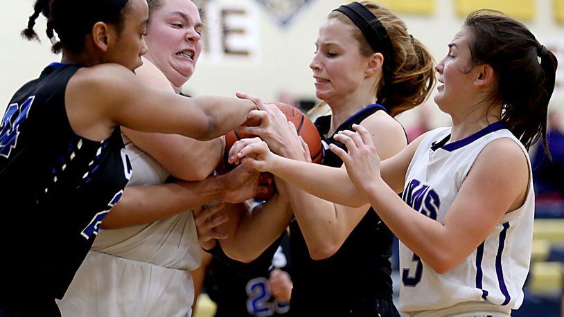 Cincinnati Christian’s Lyric Harris (left) and Allie Statzer battle for control of the ball with Miami Valley Christian Academy’s Dawsyn Vilardo and Laura Vilardo (3) during Tuesday night’s Division IV sectional game at Monroe. CONTRIBUTED PHOTO BY E.L. HUBBARD