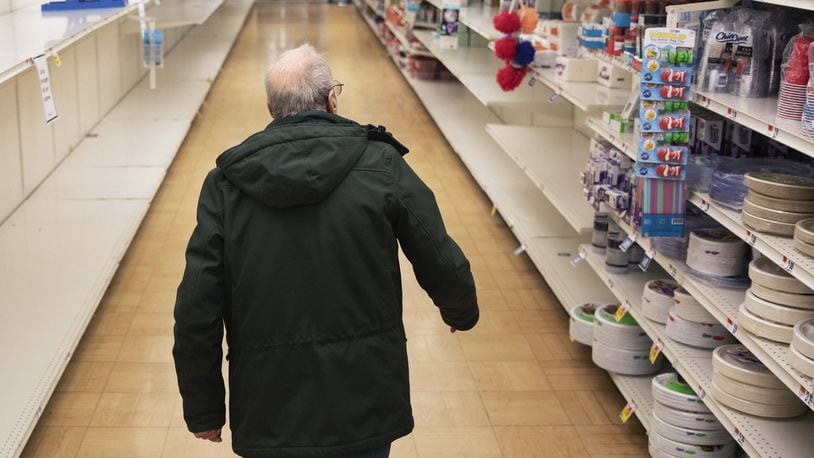 In this March 19, 2020 photo, a shopper looks for toilet paper at a Stop & Shop supermarket during hours open daily only for seniors in North Providence, R.I. Federal law enforcement is warning that scam artists are preying on older people’s fears by peddling fake tests for the coronavirus to Medicare recipients. (AP Photo/David Goldman)