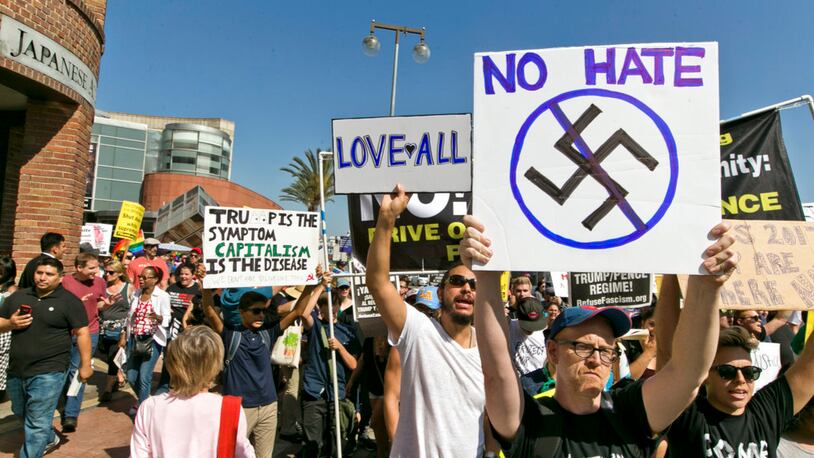 FILE--In this Aug. 13, 2017, file photo, demonstrators march in downtown Los Angeles decrying hatred and racism the day after a white supremacist rally that spiraled into violence in Charlottesville, Va. A monument at Hollywood Forever Cemetery commemorating Confederate veterans has been taken down after hundreds of people demanded its removal. (AP Photo/Damian Dovarganes, file)
