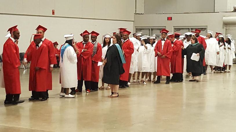 Trotwood-Madison High School staff members prepare students for their commencement ceremony last year. FILE