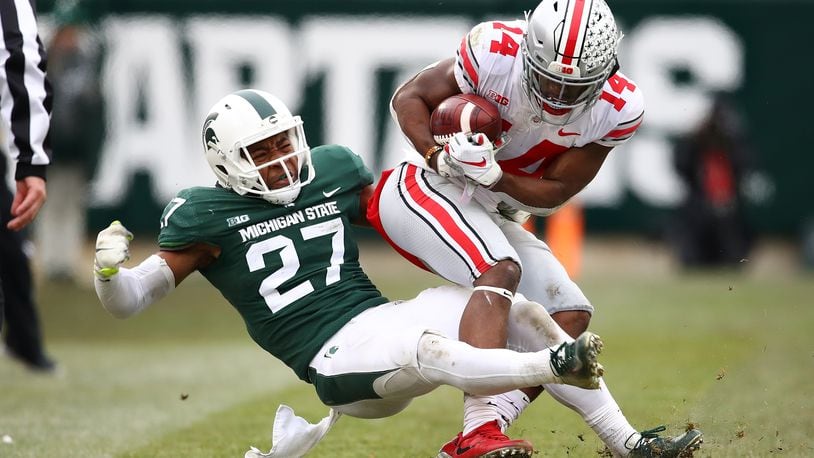 EAST LANSING, MI - NOVEMBER 10: K.J. Hill #14 of the Ohio State Buckeyes battles for yards after a second half catch while being tackled by Khari Willis #27 of the Michigan State Spartans at Spartan Stadium on November 10, 2018 in East Lansing, Michigan. (Photo by Gregory Shamus/Getty Images)