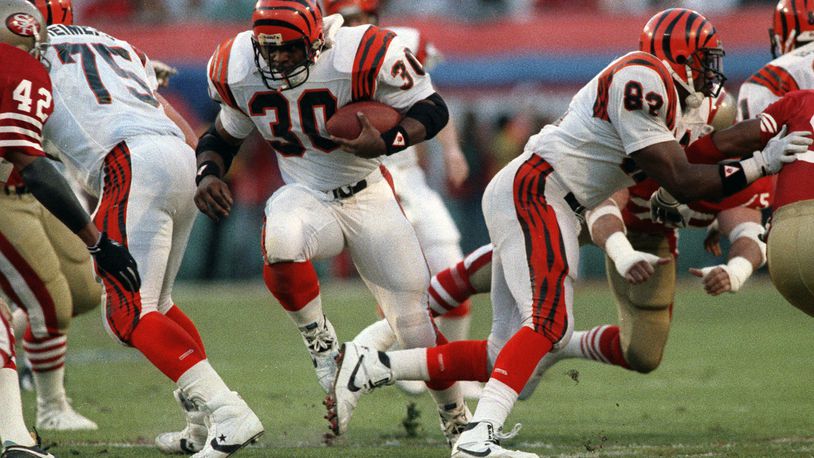 FILE - Cincinnati Bengals' Ickey Woods (30) carries the ball as teammates Bruce Reimers (75) and Rodney Holman (82) block during first-quarter action against the San Francisco 49ers in NFL football's Super Bowl XXIII game in Miami, Fla., Jan. 22, 1989. Players from the 1988 Bengals Super Bowl team are reveling the success in the current team, which is playing in the AFC championship game Sunday, Jan. 30, 2022, in Kansas City. (AP Photo/Rusty Kennedy, File)