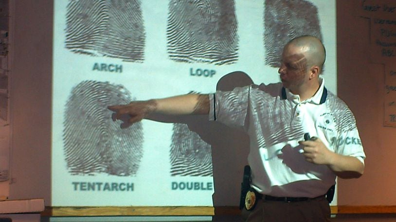 Members of the Fairfield Twp. Citizens Police Academy learn about crime scene investigations. Pictured during a class in 2009, then-Sgt. Doug Lanier talks about fingerprints. FILE