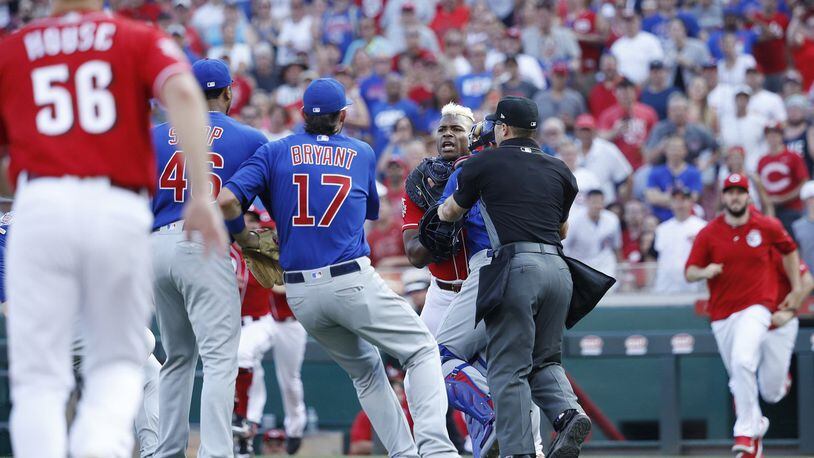 Yasiel Puig of the Cincinnati Reds is restrained after being hit by a pitch from Pedro Strop of the Chicago Cubs in the eighth inning at Great American Ball Park in Cincinnati on Saturday, June 29, 2019. The Cubs won, 6-0. (Joe Robbins/Getty Images) **FOR USE WITH THIS STORY ONLY**