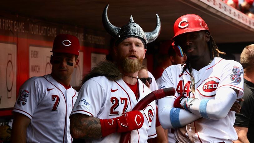 Jake Fraley, center, and Elly De La Cruz, right, pose for a photo as Spencer Steer, left, watches after Fraley's tie-breaking two-run home run in the eighth inning Wednesday against the Colorado Rockies at Great American Ball Park in Cincinnati. David Jablonski/Staff
