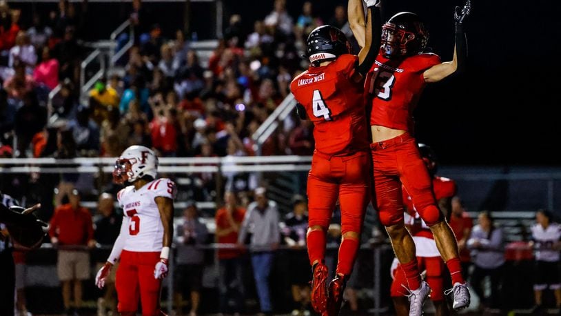 Lakota West's Ben Minich (13) celebrates his touchdown with Trent Lloyd during their football game against Fairfield Friday, Oct. 1, 2021 at Lakota West High School in West Chester Township. Lakota West won 42-10. NICK GRAHAM / STAFF
