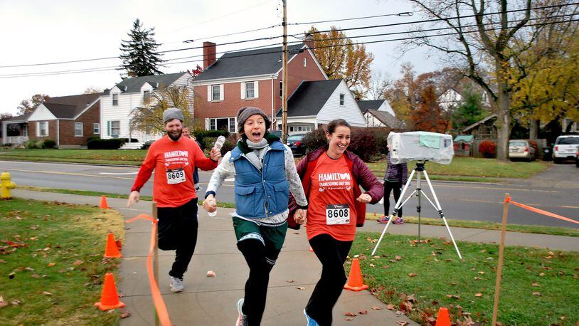 Eric Stephenson, Kristen Santos and Katie Stephenson cross the finish line at the Young Lives 5K fundraiser, which drew a record crowd on Thanksgiving Day in Hamilton.