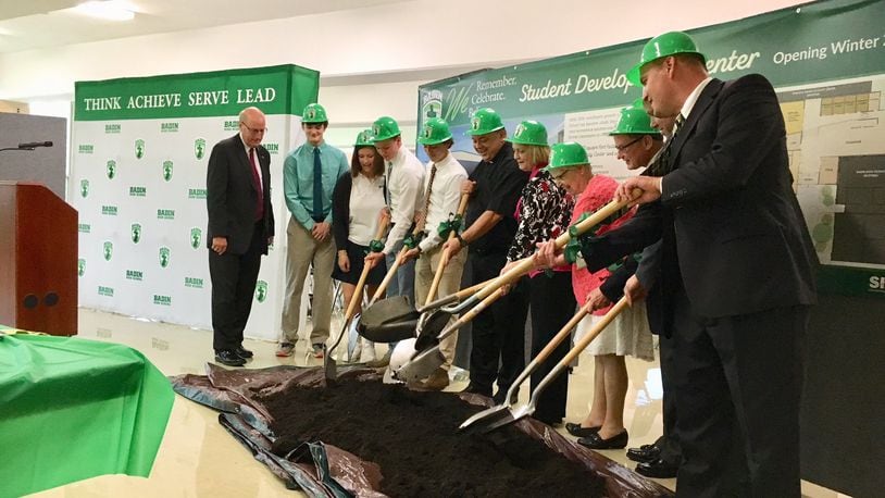 Officials from Hamilton’s Badin High School — joined by city and regional leaders — flipped ceremonial soil June 13 to mark the beginning of an $1.8 million campus expansion. MICHAEL D. CLARK/STAFF