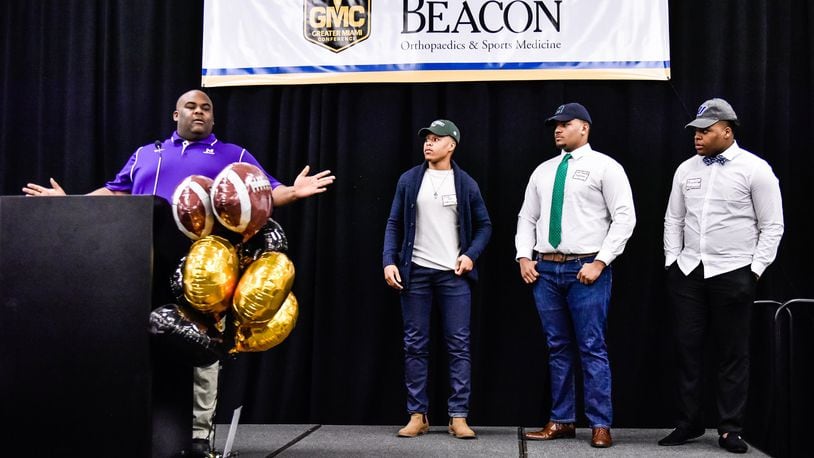 Middletown assistant coach Ayron Thompson introduces his players during the Greater Miami Conference Signing Day event Wednesday at the Sharonville Convention Center. Pictured left to right are Diondre Cooper (Mercyhurst), Ayron Thompson Jr. (Mercyhurst) and Keion Williams (Urbana). NICK GRAHAM/STAFF