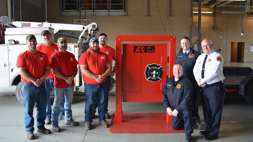 AK Steel representatives Brad Letsche, John Foster, Dan Lykins, Joe Rossi and Scott Brewer (left to right, left of door) donate and deliver a handmade fire training door to West Chester Fire Department on Dec. 12, 2019. On hand at Fire Headquarters, 9119 Cincinnati Dayton Road, to accept the door were Firefighter/Paramedic and Acting Lieutenant William Shelton (kneeling), Captain Troy Bonfield, and Assistant Chief David Pickering (left to right, right of door). CONTRIBUTED