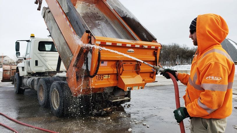 Cole Greer sprays off a salt truck at the Butler County Engineer’s Office Tuesday, Jan. 22 after two weekends of snow in the area. NICK GRAHAM/STAFF