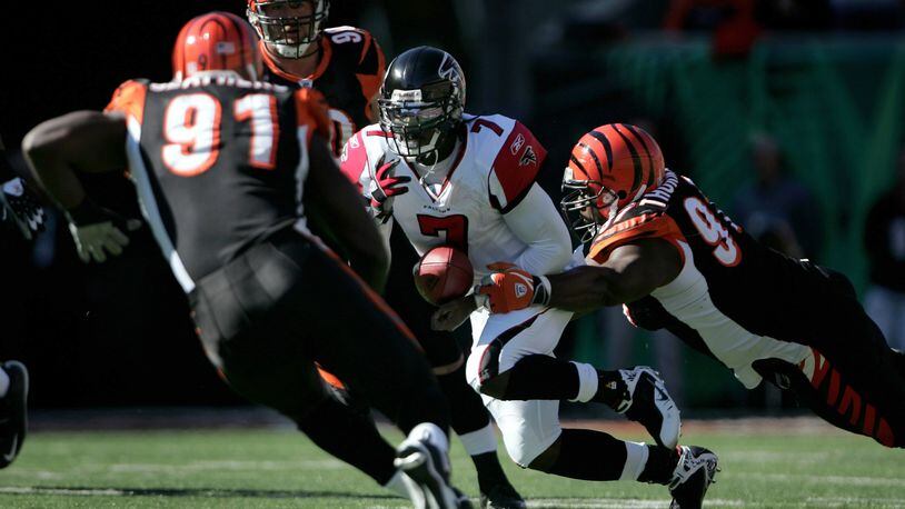 CINCINNATI - OCTOBER 29: Quarterback Michael Vick #7 of the Atlanta Falcons scrambles and has the ball knocked away by John Thornton #97 of the Cincinnati Bengals as Robert Geathers #91 and Justin Smith #90 pursue the play as the Falcons recovered the ball during the second quarter on October 29, 2006 at Paul Brown Stadium in Cincinnati, Ohio. (Photo by Doug Pensinger/Getty Images)