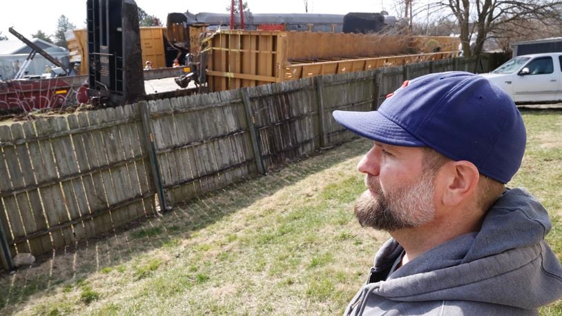 Lane Martin, the owner of Ability Builders, watches the cleanup of the train derailment on the other side of his fence Monday, March 6, 2023. Lane said he feels lucky that Saturday’s derailment stopped just before his Springfield Twp. business. BILL LACKEY/STAFF