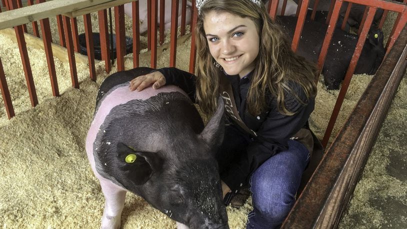 Butler County Fair Queen Micayla McClure, 17, of Harrison, with her hog, Dwight, at the fair on Monday, July 23.
