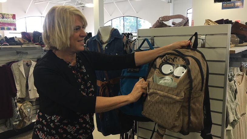 Cindy Carusone, Goodwill Easter Seals Miami Valley public relations manager, shows off a backpack at the thrift store.