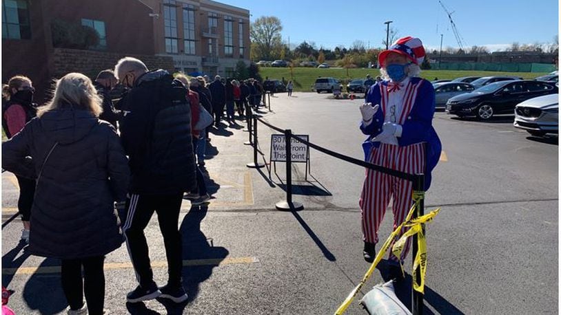 Rick Smith, a Warren County precinct official talks to voters in line for early voting Saturday at the Warren County Board of Elections office. ED RICHTER/STAFF