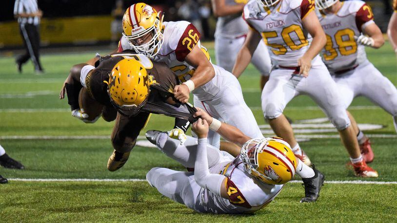 Fenwick’s Ben Gustely (47) and Logan Miller (26) tackle Alter’s Lamar Landers (6) during Friday night’s game at Centerville Stadium. Landers’ Knights won 45-20. CONTRIBUTED PHOTO BY ANGIE MOHRHAUS