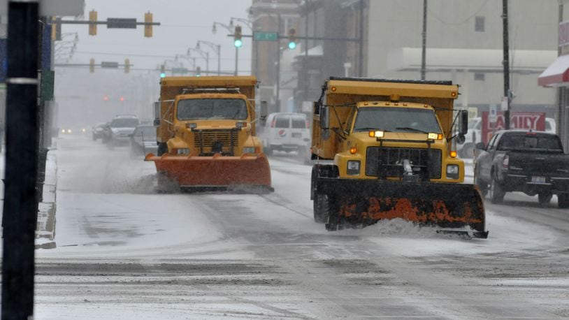 Two snow plows on Monday morning drive down Main Street approaching B Street in Hamilton. (MICHAEL D. PITMAN / STAFF)