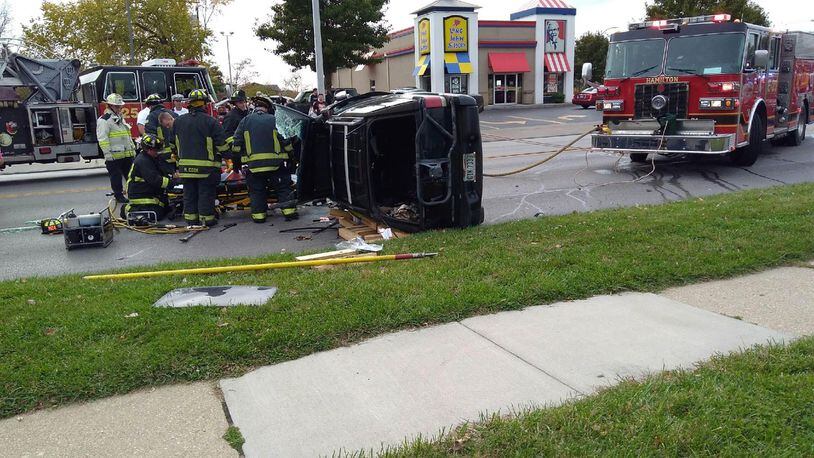 Firefighters responded to rescue a man from a vehicle on its side after a crash at NW Washington Boulevard near Brookwood Avenue Monday, Oct. 31, in Hamilton. CONTRIBUTED/RACHEL McCOY