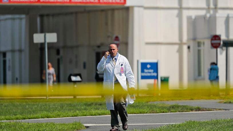 A physician walks out of the emergency entrance to Westchester Medical Center, Wednesday, Aug. 8, 2018, in Valhalla, N.Y. A man shot a female patient and then killed himself at the suburban New York hospital Wednesday, police said.