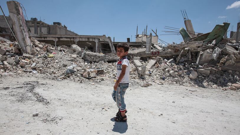 TAL ABYAD, SYRIA - JUNE 20: A boy walks past destroyed buildings in the center of the Syrian town of Kobane, also known as Ain al-Arab, Syria. June 20, 2015. Kurdish fighters with the YPG took full control of Kobane and strategic city of Tal Abyad, dealing a major blow to the Islamic State group's ability to wage war in Syria. (Photo by Ahmet Sik/Getty Images)