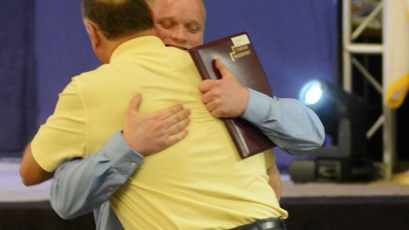 Johnny Astrop, a Navy veteran from West Chester Twp., hugs his dad, John Astrop Thursday, June 28, 2017, after he received his welding technician career passport from the Adult Workforce Development program Great Oaks. MICHAEL D. PITMAN/STAFF