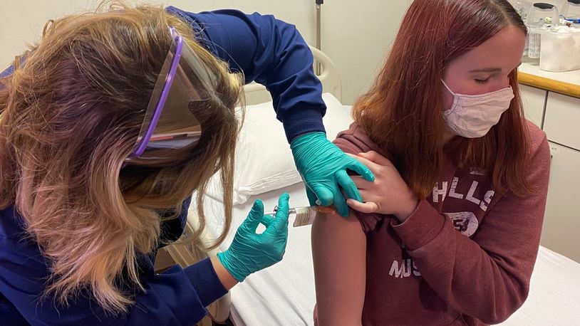 Katelyn Evans, 17, receives an injection at Cincinnati Children’s Hospital. She was the first adolescent enrolled in the COVID-19 vaccine clinical trial at Cincinnati Children’s.  PHOTO Credit Cincinnati Children’s
