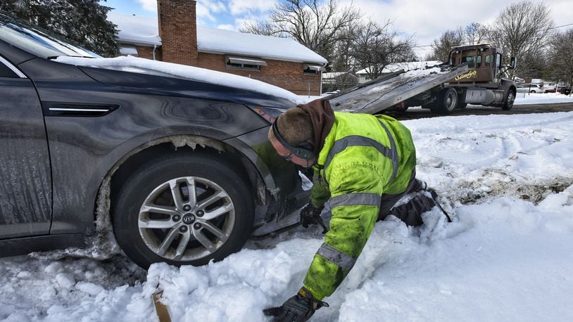 Will Lemke, with Sandy's Towing, pulls a car parked along Curryer Road out of the snow Tuesday, February 16, 2021 in Middletown. NICK GRAHAM / STAFF
