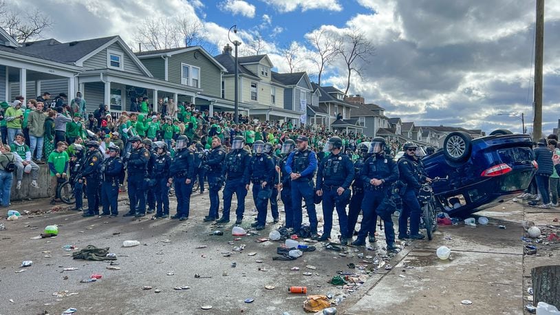 Police officers stand in formation in an attempt to quell a disturbance on Saturday, March 25, 2023, in the University of Dayton campus area. Some people overturned a vehicle, and at least six people were arrested, according to university officials. KEEGAN GUPTA/CONTRIBUTED