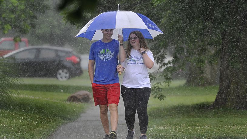 Two people walk along Shroyer Road in the rain Tuesday afternoon, June 30, 2020. MARSHALL GORBY / STAFF