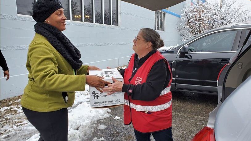 Buckeye Health Plan representative, Anisa Ballard handing their community partner a box of turkeys to support local meals this holiday season. CONTRIBUTED
