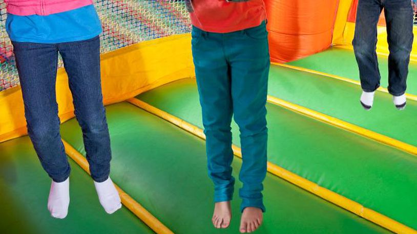 Children jumping in inflatable bouncy castle.