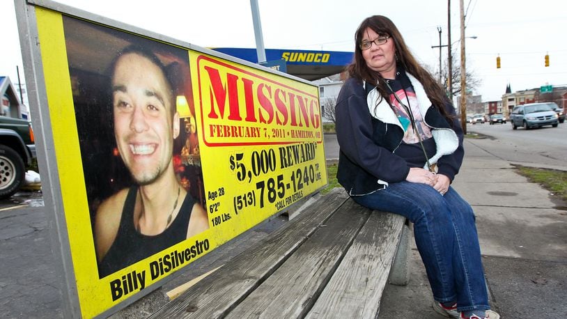 Debbie Winkler Estes sits on a bench with information about her son Billy DiSilvestro, who has been missing since 2011. Estes has become a supporter to many other local families who have loved ones that are missing. STAFF/FILE PHOTO