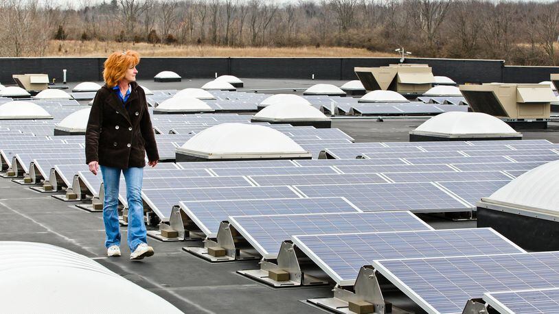 Walmart assistant manager Vicki Meredith walks past solar power arrays installed atop the Franklin location. NICK DAGGY / STAFF