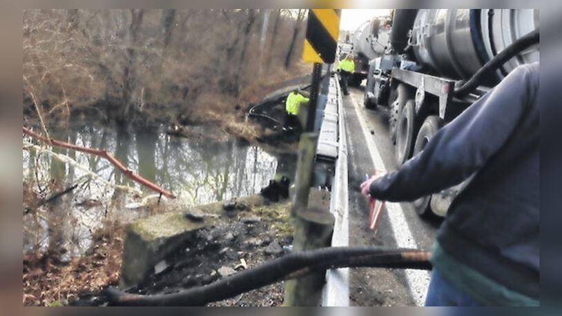 Crews vacuum surface fuel that spilled into Dutch Creek at the Gurneyville Road bridge in Liberty Twp. near Wilmington in Clinton County. CONTRIBUTED
