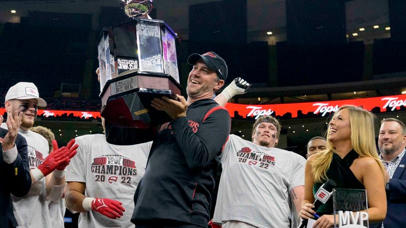Western Kentucky coach Tyson Helton holds the trophy after the team's victory over South Alabama in the New Orleans Bowl NCAA football game in New Orleans, Wednesday, Dec. 21, 2022. (AP Photo/Matthew Hinton)