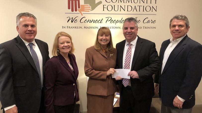 Fred DeBiasi, former president and CEO of American Savings Bank and president and COO of Valley Central Bank, presents a $100,000 check to Traci Barnett, executive director the Middletown Community Foundation. Bank executives, from left, Ben Kessling, chairman of board, Joanna Gaynor, CEO, Barnett, DeBiasi and Ed Pokora, former chairman of American Savings. RICK McCRABB/STAFF