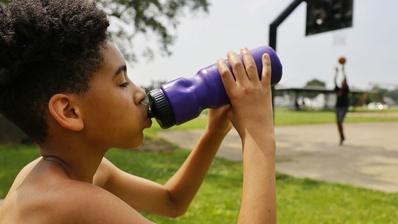 Izaiah Quinn, 11, takes a drink of water to cool off while playing basketball at Goldman Park Monday, June 13, 2022 in Middletown. NICK GRAHAM/STAFF