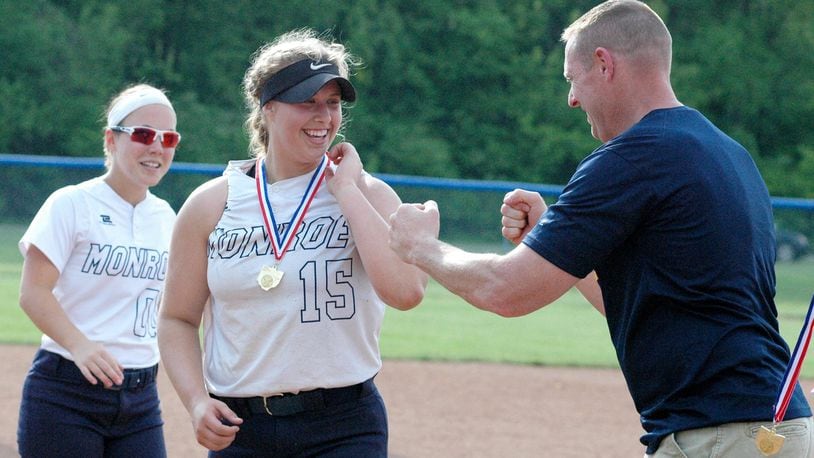 Monroe’s Bri Rose reacts during the medal ceremony with Monroe principal Tom Prohaska on Saturday after a Division II district championship softball game against Springfield Shawnee at Brookville. Monroe won 4-0. RICK CASSANO/STAFF