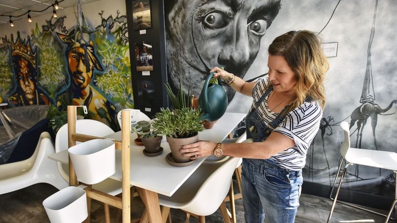 Sarah Davis waters plants at The Fringe Coffee House, which will employ felons and have a variety of musical performances and artistic murals, expects to open this fall. NICK GRAHAM/STAFF