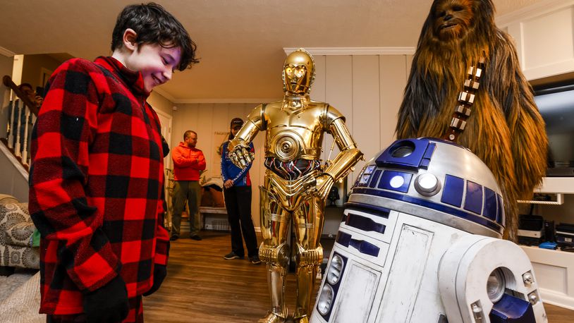 Porter Sowards, a 10-year-old who is battling brain cancer, was surprised with a visit from Star Wars characters, C3PO, portrayed by Tim O'Sullivan, R2D2 and Chewbacca, portrayed by Joey Arielle, at his home Friday, Nov. 12, 2021 in Middletown. Team Fastax also presented Porter and his family with a Dreams of Fastrax certificate for a plane ride and indoor wind tunnel session. NICK GRAHAM / STAFF