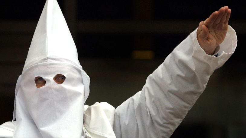 A Klansman raises his left arm during a 'white power' chant at a Ku Klux Klan rally December 16, 2000, in Skokie, Illinois.