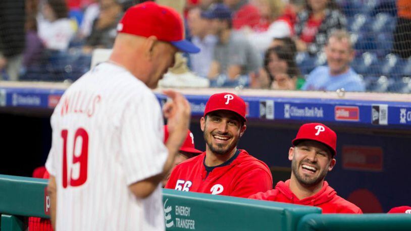 Players in the Philadelphia Phillies share a laugh after actor Bruce Willis threw out the ceremonial first pitch Wednesday.