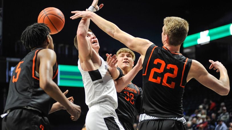Lakota East's Alex Mangold is surrounded by Beavercreek palayersSiloam Baldwin (5), Gabe Phillips (32) and Adam Duvall (22) as he goes up for a shot during their Division I District basketball final Sunday, MArch 8, 2020 at Xavier University's Cintas Center.  Lakota East won 33-32.NICK GRAHAM / STAFF