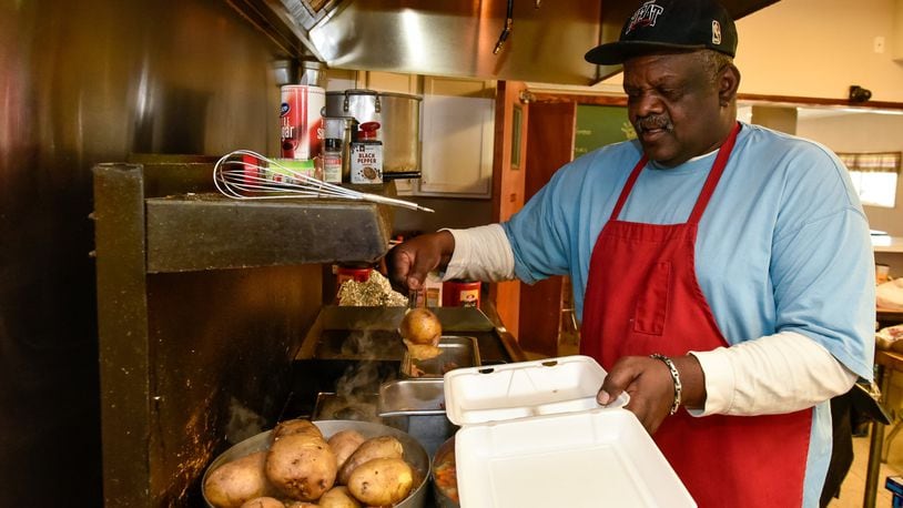 Ollie Lige dishes out a meal Monday, April 20, 2020 at Louella Thomson Cream Center Feed the Hungry Project on Yankee Road in Middletown.