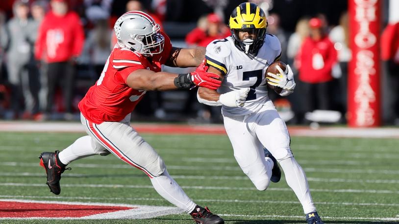 Ohio State defensive lineman Ty Hamilton, left, tackles Michigan running back Donovan Edwards during the second half of an NCAA college football game on Saturday, Nov. 26, 2022, in Columbus, Ohio. (AP Photo/Jay LaPrete)