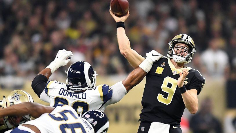 Los Angeles Rams’ Aaron Donald gets an arm on New Orleans Saints quarterback Drew Brees (9) last season. LOS ANGELES TIMES