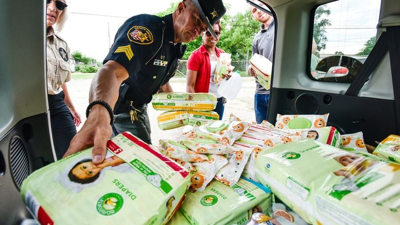 Butler County Sheriff’s Sgt. Reggie Bronnenberg helps unload diapers donated by Wayne’s Garage and Towing as the Butler County Sheriff’s Office collected nonperishable food, water and other items Friday to deliver to those hit by Monday night’s tornadoes in Montgomery, Miami and Greene counties. NICK GRAHAM / STAFF